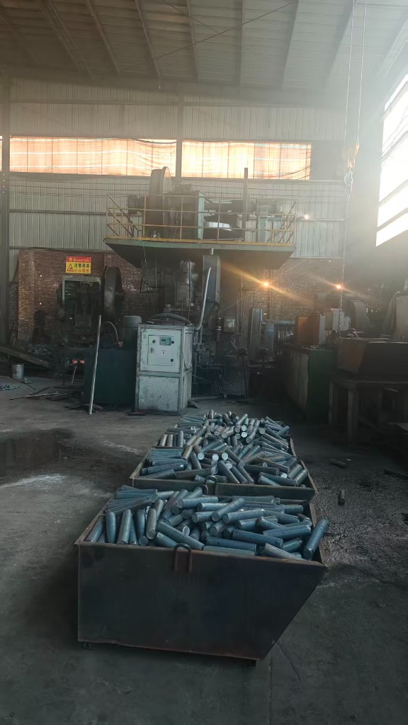 Forging press on the production floor with metal blanks ready for processing