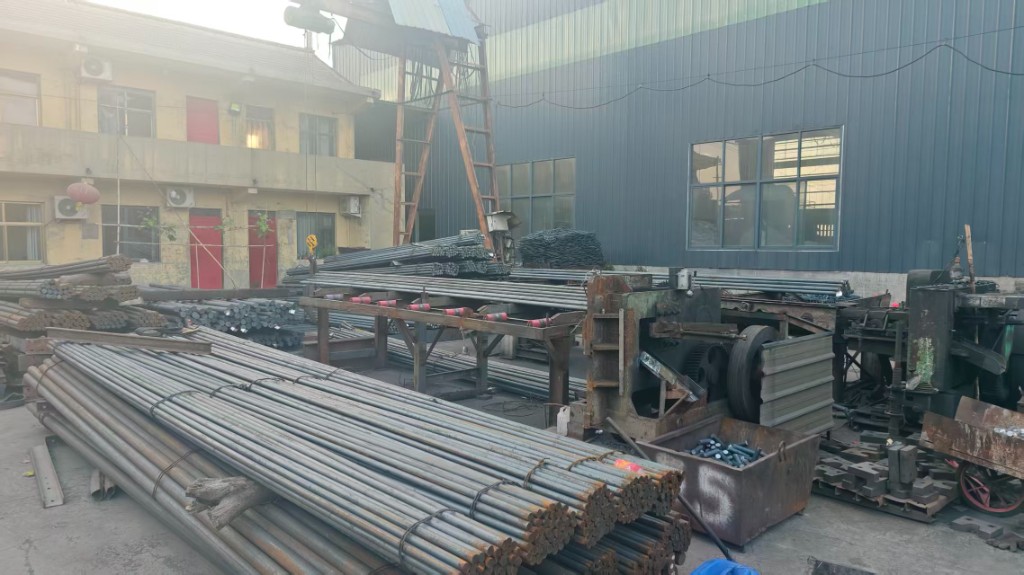 Bundled steel bar stock and material processing area at the workshop yard